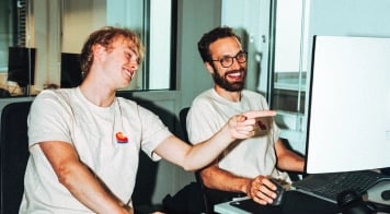 Two colleagues giving and receiving direct feedback at a computer